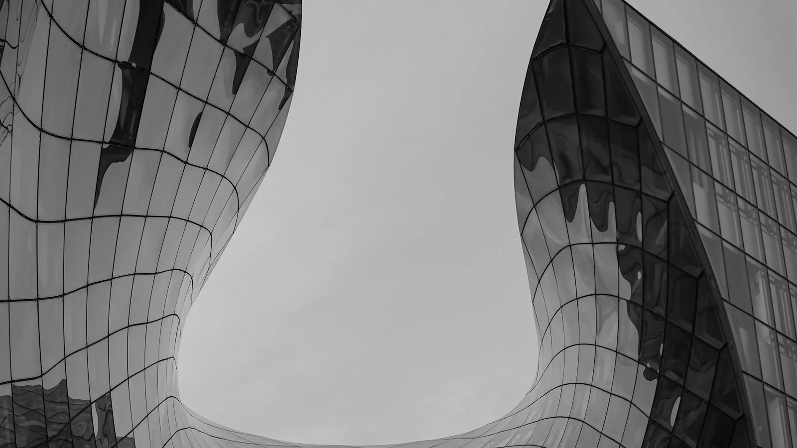 Curved glass facade folding around an open void — digital asset securitization